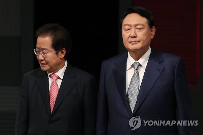 윤석열-홍준표 (서울=연합뉴스) 전수영 기자 = 국민의힘 윤석열 (오른쪽), 홍준표 대선 경선 후보가 지난 15일 저녁 서울 마포구 상암동 MBC 사옥에서 열린 '1대1 맞수토론'에 앞서 기념사진을 찍은 뒤 자리로 향하고 있는 모습. [국회사진기자단]