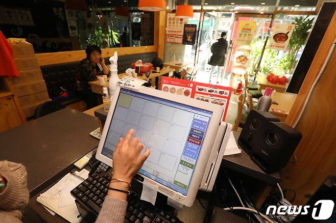 25일 정오 무렵 점심 장사를 앞둔 대구의 한 음식점에서 종업원이 작동을 멈춘 포스기를 만져보고 있다. 2021.10.25/뉴스1 © News1 공정식 기자