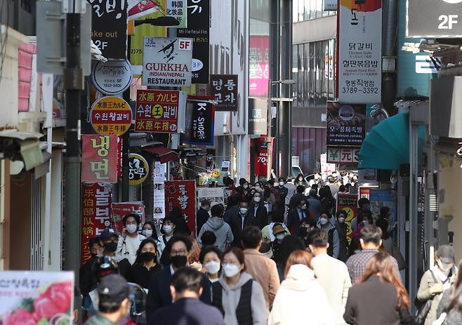 다음 달부터 본격 시행되는 '단계적 일상회복(위드코로나)' 방역체계 전환을 앞둔 25일 오후 서울 명동 거리에서 점심식사를 하려는 시민들로 붐비고 있다. /연합뉴스
