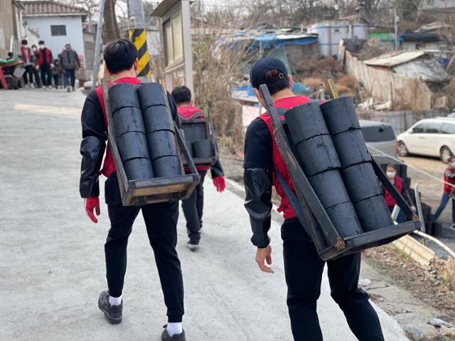 지난 3월 서울의 한 달동네를 찾은 자원봉사자들이 연탄을 배달하고 있다. 밥상공동체연탄은행 제공
