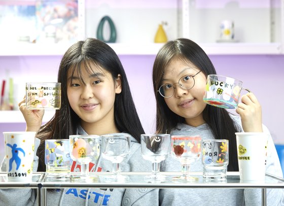 김태인(왼쪽) 학생모델·황승민 학생기자가 오브유 공방을 찾아 유리 전사지 공예를 체험했다. 완성한 컵을 들고 포즈를 취한 두 사람.