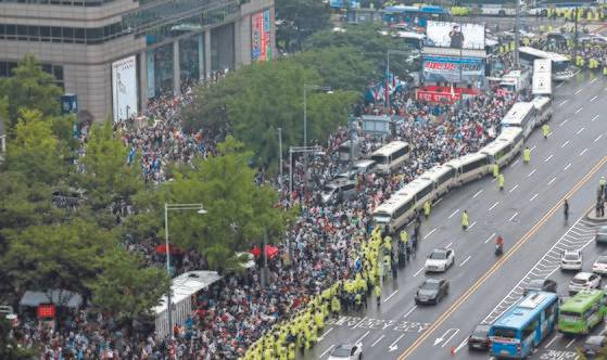 지난해 8월 15일 오후 서울 광화문 동화면세점 앞에서 보수단체들이 주최한 ‘문재인 정권 규탄’ 집회가 열렸다. 서울시는 집회를 불허했으나 법원이 이곳과 을지로입구역 등 두 곳의 집회를 허용하면서 인파가 몰렸다. [연합뉴스]