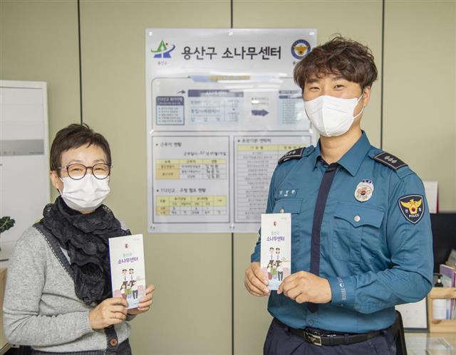 서울 용산구가 위기가정 통합지원센터의 명칭을 ‘소나무 센터’로 변경했다. 사진은 소나무 센터 안내 책자를 들고 있는 상담원(왼쪽)과 학대예방경찰관(APO)의 모습.용산구 제공