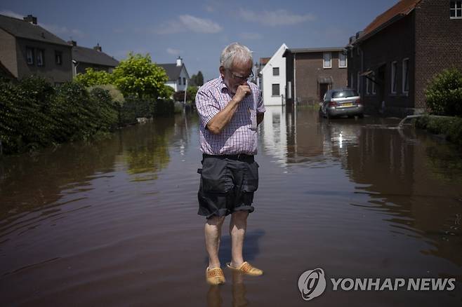지난 7월 네덜란드 한 도시에서 한 주민이 홍수에 잠긴 자택 밖에 서 있다. [AP 연합뉴스 자료사진]