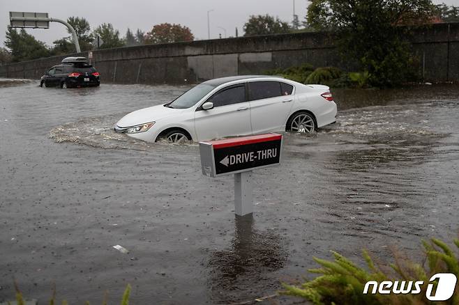 24일(현지시간) 미국 캘리포티아주를 강타한 태풍으로 인해 침수된 도로를 자동차가 건너고 있다. © 로이터=뉴스1 © News1 신윤하 기자