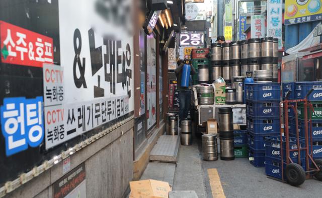 25일 서울의 한 유흥거리에서 관계자가 맥주 박스를 옮기고 있다. 그동안 집합금지였던 유흥시설은 '위드코로나' 1단계 조치가 시작되는 1일부터 자정까지 영업이 허용되지만 유흥시설에 출입하기 위해선 백신패스가 필요할 전망이다. 뉴스1