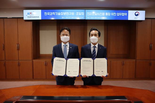 김재수 KISTI 원장(오른쪽)과 김정우 조달청장이 협약서를 들어보이고 있다.[KISTI 제공]