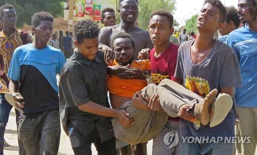 반쿠데타 시위 도중 부상한 남성을 옮기는 하르툼 시민들. [AFP 연합뉴스. 재판매 및 DB 금지]