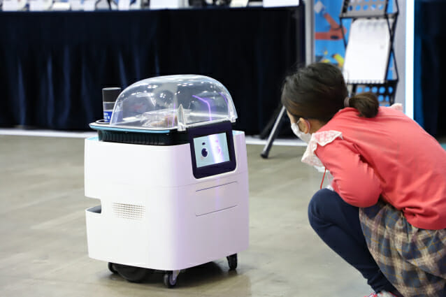 2020 로보월드에서 한 시민이 자율주행로봇과 눈을 맞추고 있다.