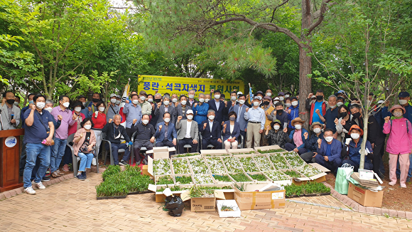 풍란. 석곡자생지 복원사업 관계자들이 화이팅을 외치고 있다 [사진=신안군청]