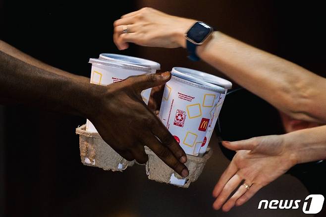맥도날드 종업원이 고객에게 음료를 건네고 있다. © AFP=뉴스1