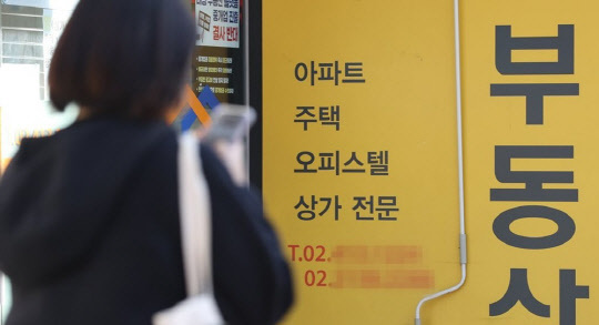 한 시민이 부동산공인중개업소 앞에서 매물정보를 확인하고 있다. <연합뉴스>