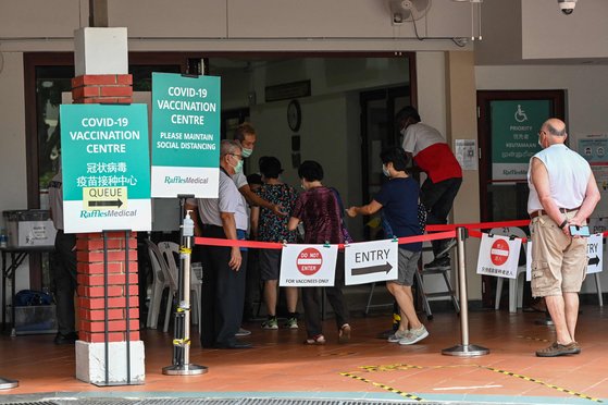 지난 7일 싱가포르의 한 커뮤니티센터에서 시민들이 코로나19 백신접종을 위해 줄을 서고 있다. AFP=연합뉴스
