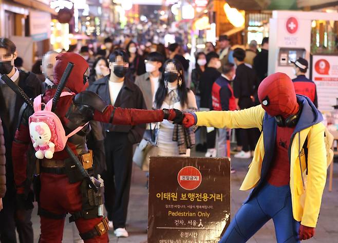 핼러윈 데이를 앞둔 29일 인파가 몰린 서울 용산구 이태원 세계음식특화거리에서 스파이더맨 등 영화 캐릭터 복장을 한 시민들이 인사를 나누고 있다. /연합뉴스