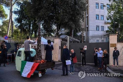 홍콩 민주운동가 네이선 로, 이탈리아 주재 중국대사관 앞서 시위  (로마 AFP=연합뉴스) 위구르 인권운동가 라히마 마무트와 홍콩 민주운동가 네이선 로(트럭 위 왼쪽)가 27일(현지시간) 이탈리아 로마 주재 중국 대사관 앞에서 트럭에 올라탄 채 시위를 벌이는 모습. 두 사람 사이에 놓인 것은 톈안먼 민주화시위를 상징하는 조각상 '수치의 기둥'의 모형이다. 2021.10.29. photo@yna.co.kr