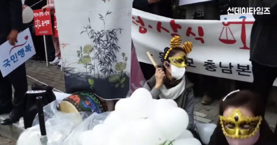 윤석열 전 검찰총장의 지지층이 앉아서 북과 징을 치고 있다. 유튜브 채널 '선데이타임즈' 화면캡처.