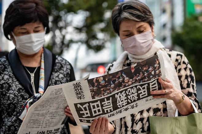 일본 국민들이 지난달 29일 신문에 실린 자민당 총재 선거 결과를 읽고 있다. /사진=AFP