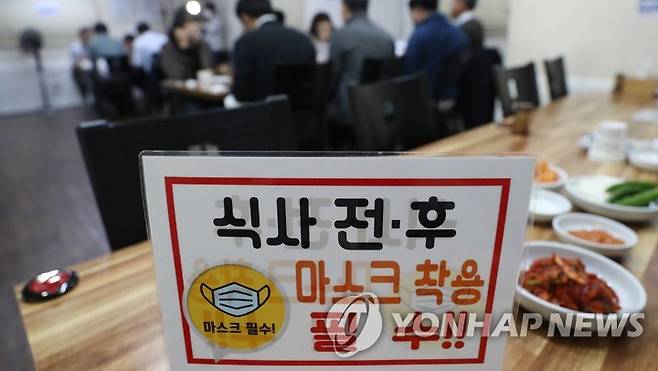 식사 전·후 방역수칙 강조    지난 18일 직장인들이 점심을 먹고 있는 모습. [연합뉴스 자료사진]