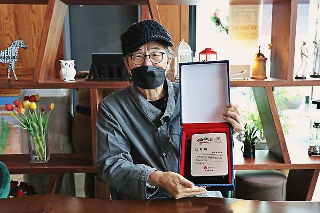 빠삐코 아이스크림 포장에 삽입된 만화 '고인돌'을 그린 작가 박수동씨가 롯데푸드에서 준 감사패를 들고 있다.(롯데푸드 제공) © 뉴스1