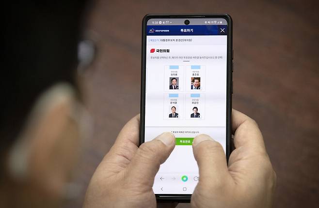 국민의힘 한 당원이 1일 국회 사무실에서 대선후보 선출을 위한 전당대회 투표 당원 모바일 투표를 하고 있다. 국민의힘 전당대회 투표는 4일까지 나흘간 진행된다. 당원 투표와 일반국민 여론조사가 절반씩 반영되며 그 결과는 오는 5일 공개된다. 당원 투표는 오는 1∼2일 모바일 투표와 3∼4일 ARS 전화 투표 순으로 진행되며, 여론조사는 3∼4일 이틀 동안 전화 면접 방식으로 별도 진행된다. 국회사진기자단