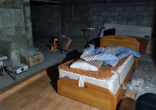 The rest area for security guards in an apartment complex in Yongsan-gu, Seoul. There is one bed in a space surrounded by exposed cement walls. Kang Han-deul