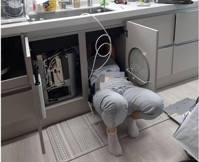 정수기 관리 매니저가 새로 출시된 싱크대 수전형 정수기를 점검하고 있다. 금속노조 제공