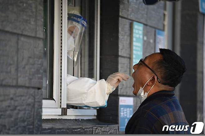 지난달 27일(현지시간) 중국 베이징의 병원에 마련된 코로나19 검사소에서 주민이 면봉 검사를 받고 있다. © AFP=뉴스1 © News1 우동명 기자