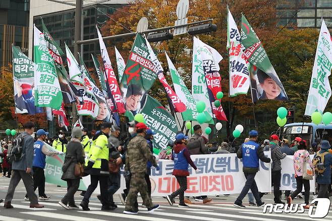 위드 코로나 시행 후 첫 주말인 6일 오후 보수단체 회원들이 서울 광화문 일대에서 집회를 마치고 행진하고 있다. 2021.11.6/뉴스1 © News1 성동훈 기자