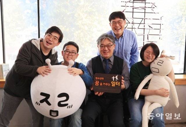 1일 서울 관악구의 프레네스쿨 별이 운영하는 카페에서 김현수 교장(왼쪽에서 세 번째)과 스타 칼리지 졸업생 및 재학생들이 학교를 
상징하는 인형을 들고 활짝 웃고 있다. 카페 등록 상호는 ‘아자라마’이지만 교사들과 학생들이 원한 이름은 초성으로만 쓴 
‘ㅇㅈㄹㅁ’ 였다. ‘완전하지 않은, 애매한 상태의 경계인’을 표현하고자 했다.  장승윤 기자 tomato99@donga.com