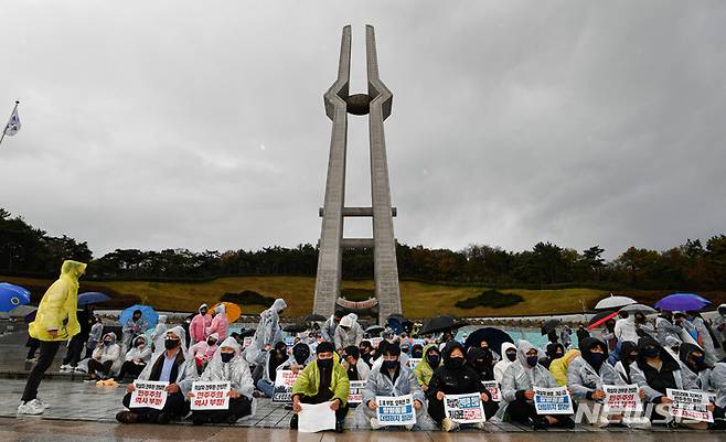 [광주=뉴시스] 류형근 기자 = 10일 광주 북구 국립 5·18 민주묘지에서 윤석열 국민의힘 대선 후보의 방문을 항의하는 시민들이 충혼탑 앞에서 손팻말을 들고 있다. (공동취재사진) 2021.11.10. photo@newsis.com