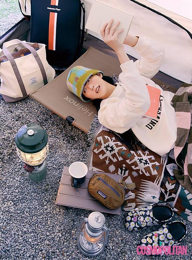 스웨트셔츠 5만7천원 디어디어. 모자 18만9천원 아더에러. 슬리퍼 5만9천원 크록스. 다리에 덮은 재킷 51만3천원 올세인츠. 슬리퍼에 장식된 참 모두 가격미정 크록스. 백팩 16만원 오니츠카타이거. 숄더백 가격미정 뉴발란스. 미니 백 4만9천원 파타고니아. 야전침대 33만원 헬리녹스. 담요 6만9천원 블랑쉬하우스. 컵 1만8천원 코오롱스포츠. 테이블, 램프 포토그래퍼 소장품.