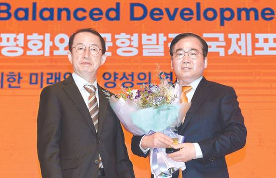 Lee Ha-kyung, right, director of the Korea Peace Foundation, receives the inaugural Northeast Asia + Peace Award at the 3rd Annual East Asia Peaceful and Balanced Development Forum in Daejeon on Wednesday. The prize was presented by Chairman Kim Sa-yeol of the Presidential Committee for Balanced National Development. [KIM SEONG-TAE]