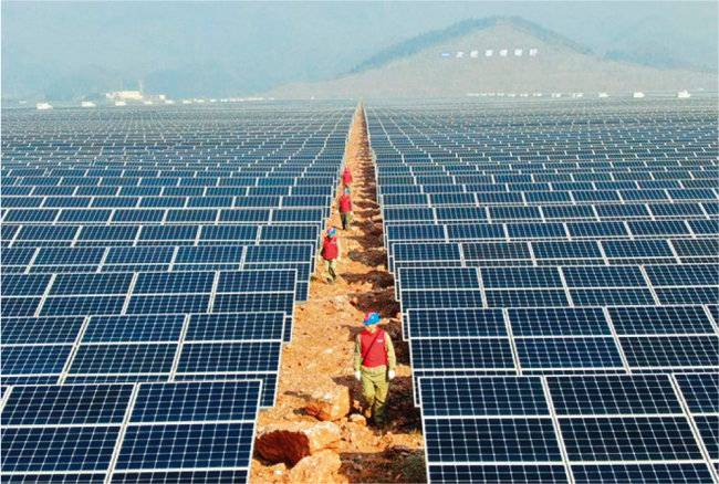 중국 기술자들이 태양광 패널을 점검하고 있다. [Caixin Global]