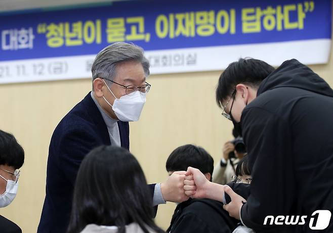 전국 민생탐방 투어에 나선 이재명 더불어민주당 대선 후보가 12일 오후 울산 남구 시의회 대강당에서 열린 '청년이 묻고, 이재명이 답하다' 울산 청년들과의 대화에 참석하며 청년들과 인사를 나누고 있다. 이 후보는 이날 부산·울산·경남을 시작으로 약 8주간 버스를 타고 전국 곳곳의 목소리를 경청하는 매타버스(매주 타는 민생버스) 프로젝트에 돌입했다. 2021.11.12/뉴스1 © News1 오대일 기자