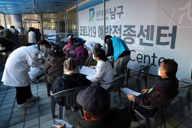 ▲15일 오전 광주 남구 다목적체육관에 마련된 코로나19 예방접종센터에서 백신 추가접종(부스터샷)을 받으러 온 주민이 문진표를 작성하고 있다. 연합뉴스