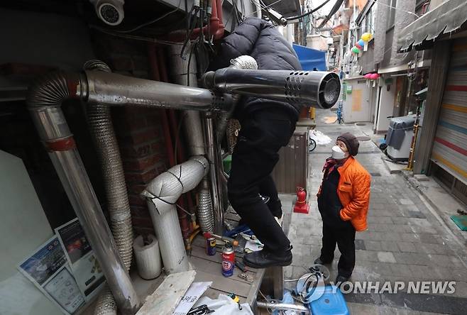 취약계층에 더 혹독한 한파 (서울=연합뉴스) 이정훈 기자 = 11일 오전 서울 종로구 돈의동 쪽방촌에서 한 자원봉사자가 동파로 고장난 보일러를 수리하고 있다. 2021.1.11 uwg806@yna.co.kr