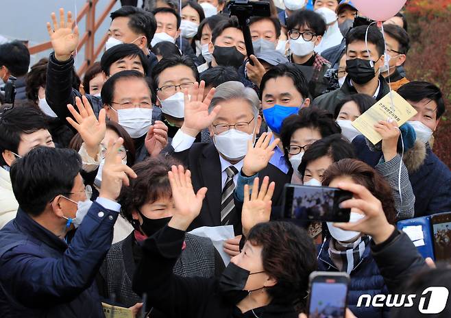 이재명 더불어민주당 대선 후보가 '매타버스(매주 타는 민생버스)' 충청권 지역순회 이틀째인 20일 오전 충남 논산 탑정호 일대에서 시민들과 함께 사진을 찍고 있다. 이 후보는 지난주 부산·울산·경남 지역순회에 이어 '매타버스'를 타고 2박3일 일정으로 충청지역을 순회한다. 2021.11.20/뉴스1 © News1 구윤성 기자