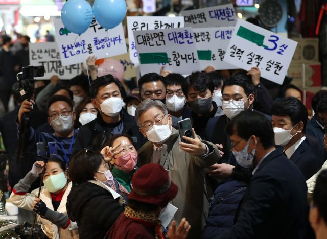 이재명 더불어민주당 대선 후보가 20일 충남 논산시 화지중앙시장을 방문해 지지자들과 기념촬영을 하고 있다. 연합뉴스