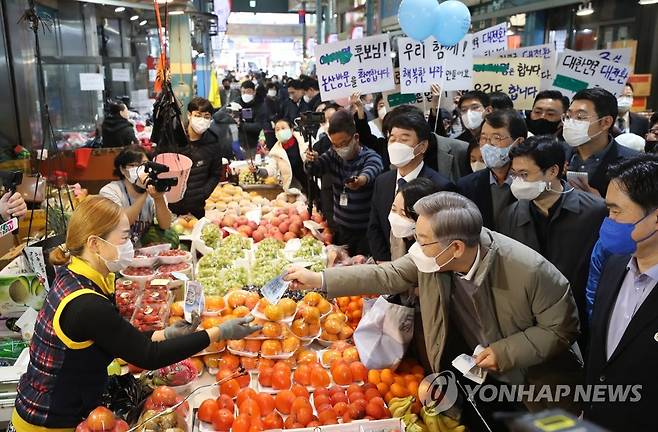 화지중앙시장에서 물건 사는 이재명 대선후보 (논산=연합뉴스) 백승렬 기자 = 더불어민주당 이재명 대선후보가 20일 충남 논산시 화지중앙시장을 방문, 물건을 사고 있다. 2021.11.20 srbaek@yna.co.kr