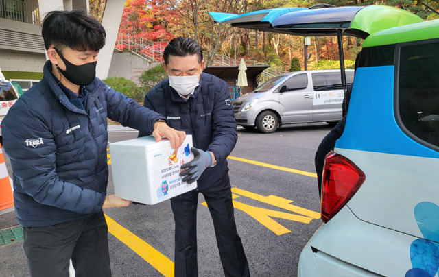 김인규 하이트진로 대표(오른쪽)가 22일 구립서초노인요양센터에서 사회복지기관에 김장김치를 전달하고 있다. /하이트진로 제공