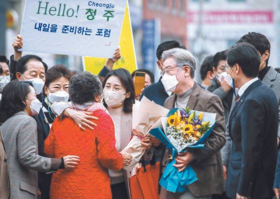 이재명 더불어민주당 대선후보와 부인 김혜경씨(오른쪽 둘째부터)가 21일 충북 청주시 육거리종합시장을 방문해 시민들과 인사하고 있다. [뉴시스]