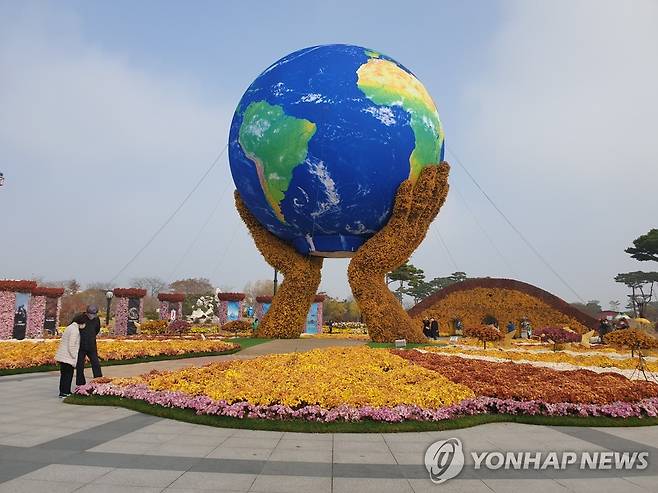 주말 맞아 함평 국향대전 즐기는 나들이객 (함평=연합뉴스) 주말인 20일 낮 전남 함평군 함평 엑스포공원에서 '2021년 대한민국 국향대전'을 찾은 나들이객들이 국화로 만들어진 화려한 조형물을 감상하고 있다. 2021.11.20 [독자 제공. 재판매 및 DB 금지] areum@yna.co.kr