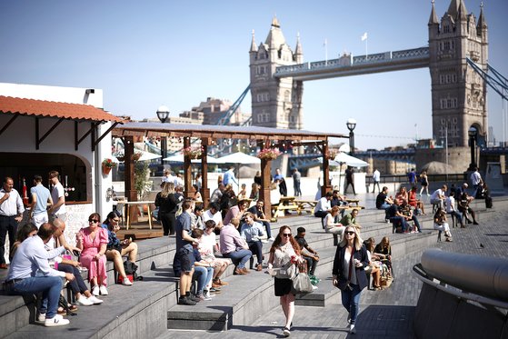 위드 코로나 정책이 시행 중인 영국 런던의 시민들이 지난 9월 타워브리지 인근 템스강변에서 햇살을 즐기고 있다. [로이터=연합뉴스]