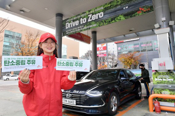 SK에너지 직원이 25일 탄소 중립 석유제품을 판매하는 드라이브 투 제로(Drive To Zero) 캠페인을 홍보하고 있다. SK이노베이션 제공