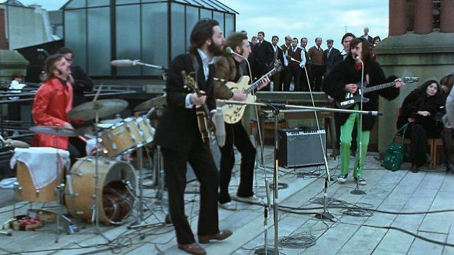 저유명한 미국 뉴욕 맨해튼의 애플 레코드 건물 옥상을 찾아 벌인 비틀스의 잼(즉석) 공연 모습. 오른쪽 끝에 오노 요코의 모습이 눈에 띈다.디즈니＋ 제공영국 BBC 홈페이지 재인용