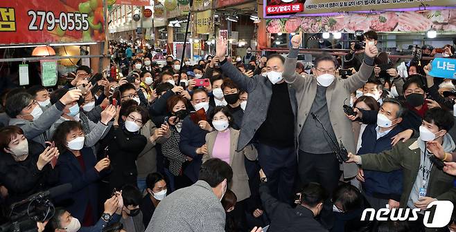 이재명 더불어민주당 대선후보가 26일 오후 전남 목포시 동부시장을 찾아 김원이 국회의원과 함께 시장 상인들에게 큰 목소리로 인사하고 있다. 2021.11.26/뉴스1 © News1 황희규 기자