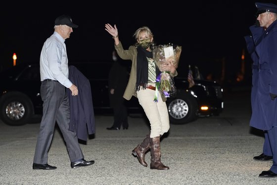질 바이든 여사가 23일(현지시간) 낸터켓 섬으로 가는 에어포스원에 오르기 전 손을 흔들고 있다. 질 여사는 무릎 길이 부츠를 신고 꽃을 들었다. [AFP=연합뉴스]