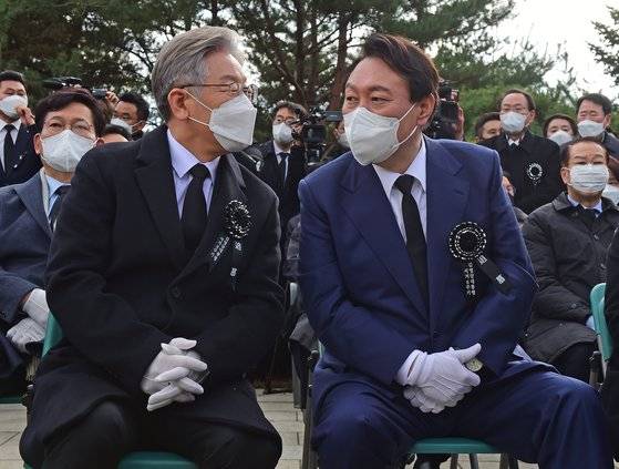 백발이었던 이재명 더불어민주당 후보(왼쪽·57)는 윤석열 국민의힘 대선 후보(오른쪽·61)보다 네 살 적다. 두 사람이 22일 서울 동작구 국립서울현충원 내 김영삼 전 대통령 묘역에서 열린 6주기 추모식에서 이야기를 나누고 있다. 국회사진기자단