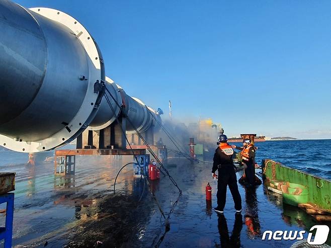 27일 오후 2시 35분께 울산항 1항로를 지나던 731톤급 바지선에서 불이 나 소방 관계자들이 진화작업을 하고 있다.(울산해양경찰 제공)© 뉴스1