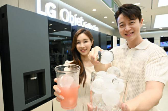 모델들이 LG 디오스 얼음정수기냉장고 오브제 컬렉션의 원형 얼음인 크래프트 아이스를 들고 소개하고 있다. [LG전자 제공]